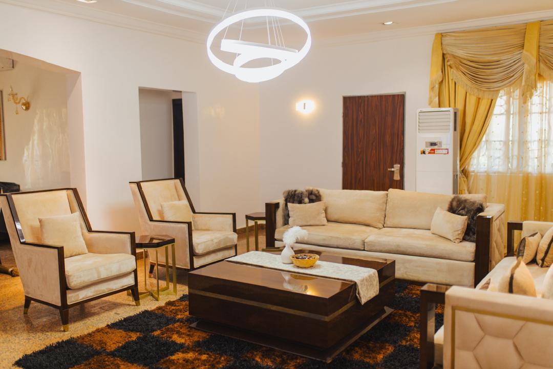 Main parlor with armchairs and a ring chandelier